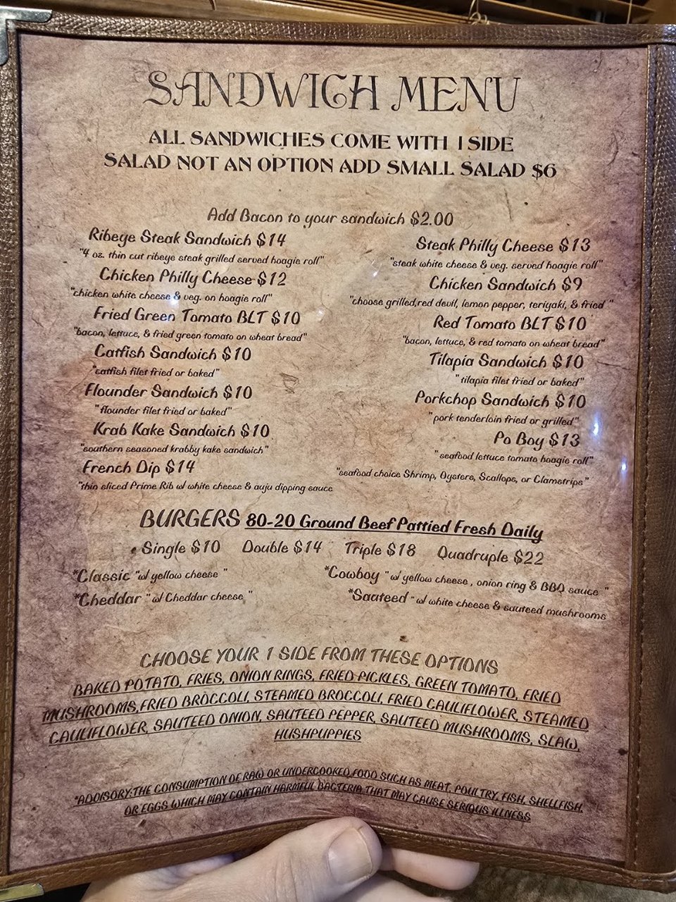 Printed menu beside a steak and seafood dish.